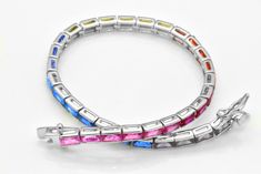 Here we have a beautiful and exquisite multi-color simulated sapphire tennis bracelet. All emerald cut gemstones are bezel set. There is an impressive 8 cts of weight of gemstones. The bracelet is 7-inches long and about 1/8-inch thick. This bracelet was designed to allure and impress with beautiful 14k white gold finish. It will be an excellent addition to a jewelry collection due to its uniqueness. Why spend thousands for the same look. The bracelet is made out of solid 925 Sterling Silver wit Sapphire Tennis Bracelet, Birthday Bracelet, Eternity Band Ring, Tennis Bracelet, Italian Charm Bracelet, Chain Link Bracelet, Bezel Setting, Eternity Ring, Emerald Cut