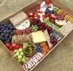 a box filled with lots of different types of fruit and cheese on top of a table