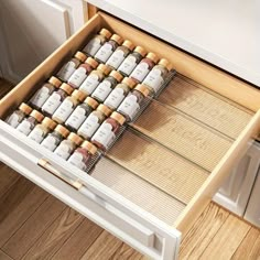 an open drawer with bottles in it on top of a wooden floor next to drawers