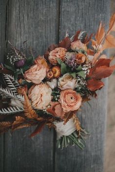 a bouquet of flowers sitting on top of a wooden fence