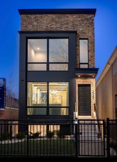 a modern house with large windows and black iron fence