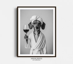 a black and white photo of a dog wearing a robe holding a glass of wine