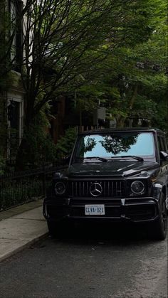 a black mercedes parked on the side of a street