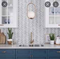 a kitchen with blue cabinets and white counter tops, gold pulls on the cupboards