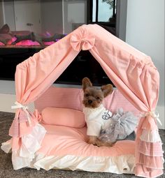 a small dog sitting on top of a pink bed