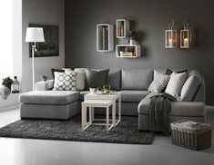 a living room with grey walls and white flooring, gray couches and pillows