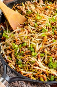 a skillet filled with meat and veggies on top of a table