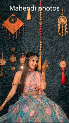 a woman sitting on top of a chair in front of a wall covered with ornaments