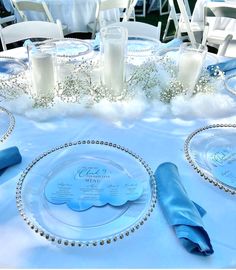 the table is set with blue napkins and place settings for guests to sit at