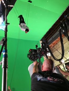 a man is filming in front of a green screen