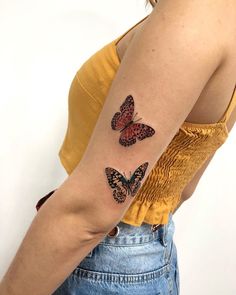 a woman's arm with two butterflies on the left side of her arm,