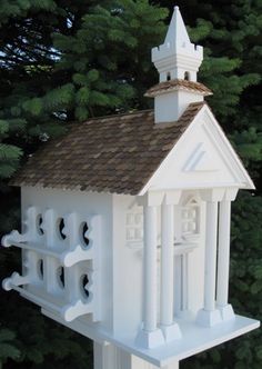 a white bird house with a brown roof