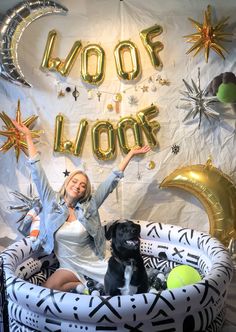 a woman and her dog pose for a photo in front of a backdrop that says woop loon