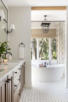 a bathroom with a large tub next to a window