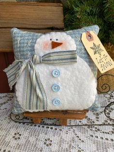 a snowman pillow sitting on top of a wooden sled