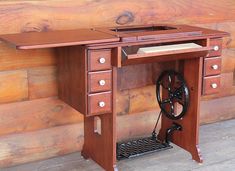 an antique sewing table with wheels and drawers on the top, in front of a wood paneled wall