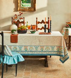 a dining room table is set with fruit and candles