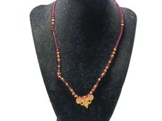 This necklace has a very small gold-tone pendant that lights up the whole necklace. It measures 1 inch wide by .5 inches long. The beads are a stunning red glass. This is perfect for someone who likes just a touch of drama in their dress. Red Spiritual Jewelry With Gold Beads, Gold Beaded Pendant Necklace For Celebration, Gold Pendant Beaded Necklace For Celebration, Spiritual Red Jewelry With Gold Beads, Red Beaded Amulet Style Jewelry, Vintage Red Necklace For Celebration, Gold Beaded Pendant Necklaces, Red Pendant Necklaces For Celebration, Red Vintage Necklace For Celebration