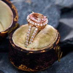 an engagement ring is sitting on top of a velvet box with its reflection in it