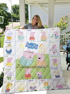 a woman holding up a peppa pig quilt