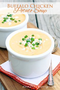 two white bowls filled with soup on top of a wooden cutting board