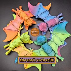 there are many different colored dragon figurines on the table with text reading moreno creative?