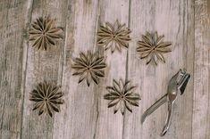 a pair of pliers sitting on top of a wooden table next to paper flowers