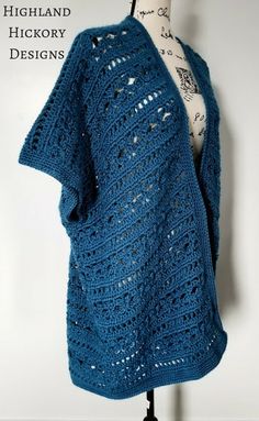 a blue crocheted shawl sitting on top of a mannequin