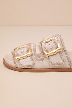 Everyone loves a slide-on sandal for the summertime, and the Schutz Enola Sporty Casual Oyster Buckled Slide Sandals are our favorite pick for this season! These trendy sandals feature an open-toe upper and wide, woven fabric straps with adjustable, chunky gold bamboo-inspired buckles for a statement-making finish. Style with a breezy, wide-leg jumpsuit to keep yourself stylishly cool! 1. 25" sole. Smooth insole. Felted rubber sole has nonskid markings. Man made materials. Imported. Lulus | Enol Summer Slip-on Mules With Buckle Closure, Beige Round Toe Slides For Beach, Beige Round Toe Slides For The Beach, Beige Slides For Beach, Open Toe Footbed Sandals For Beach Season, Beige Round Toe Slides For Vacation, Casual Gold Slides For Vacation, Poolside Slip-on Sandals With Textured Footbed, Beige Slide Mules With Cushioned Footbed