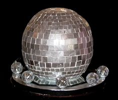 a silver disco ball and some balls on a black surface