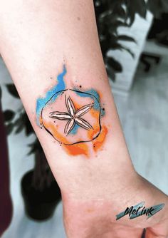 a small starfish tattoo on the left inner arm and wrist is painted with watercolors