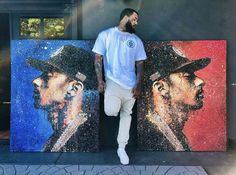 a man standing in front of two paintings with one wearing a hat and the other holding his hand on his hip