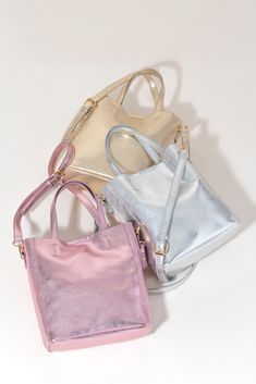 Make a statement this summer with Shiraleah's Maddie Tote. Made from metallic PU, this shiny accessory is sure to turn heads. With double shoulder straps and plenty of storage room, you won't need another bag to get you through this summer. Pair with other Shiraleah items to complete your look! Features double shoulder straps, magnetic snap closure, 2 outer slip pockets, and 1 inner slip pocket Shiraleah is a trend-driven lifestyle brand focused on the little gifts that make life special! Made f Spa Wraps, Baby Bubble Romper, Accessories Display, Luggage Backpack, Hair Accessories Jewelry, Storage Room, Framed Gifts, Zip Pouch, Garment Bags