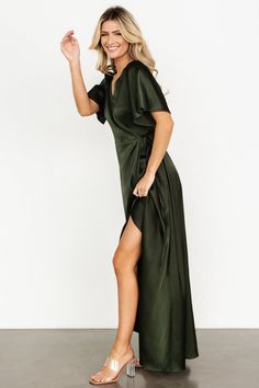 a woman in a green dress posing for the camera