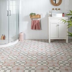 a bathroom with a checkered floor and pink towels hanging on the shower stall door