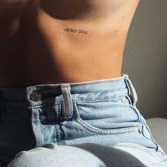 the back of a woman's stomach with a small tattoo on her left side