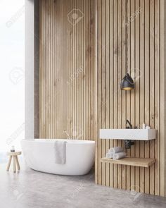 a white bath tub sitting next to a wooden wall