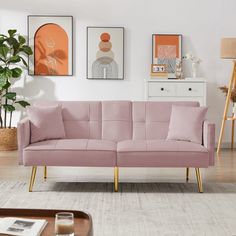 a living room with pink couches and pictures on the wall above it, along with a coffee table