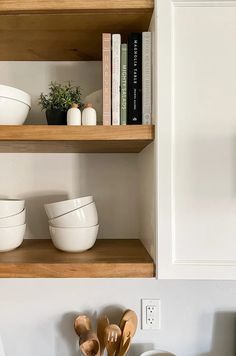 wooden spoons and bowls are sitting on the shelves