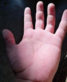 a person's hand covered in water on top of a table