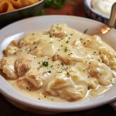 a white plate topped with dumplings covered in gravy