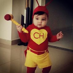 a young child dressed in a costume holding a baseball bat