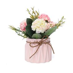 a pink vase filled with flowers and greenery