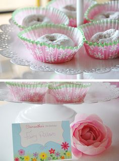 there are pink and green cupcakes on the cake plate with a name tag