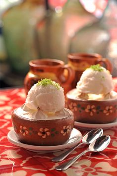 two dessert dishes on a table with utensils