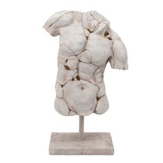 a white sculpture on a wooden stand with rocks in the shape of an animal's head