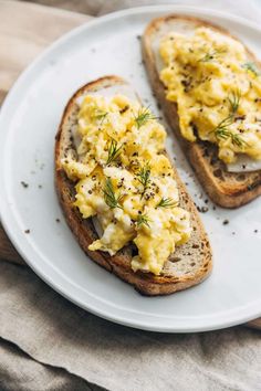 two pieces of bread with scrambled eggs on them