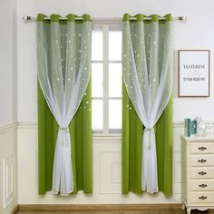 green and white curtains hanging on the side of a window in front of a dresser