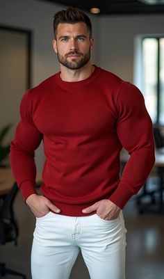 a man in a red sweater and white pants posing for the camera with his hands on his hips