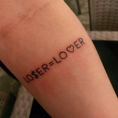 a person with a tattoo on their arm has the word lover written in black ink